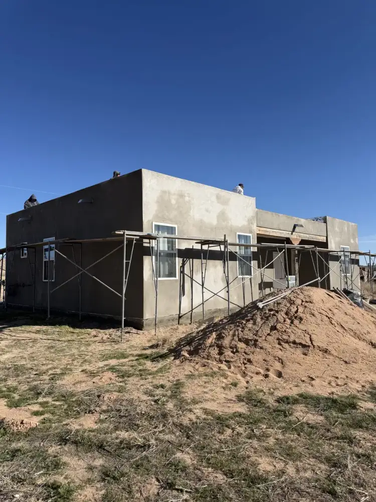 New home with the brown coat carried right around the walls and scaffolding still standing.